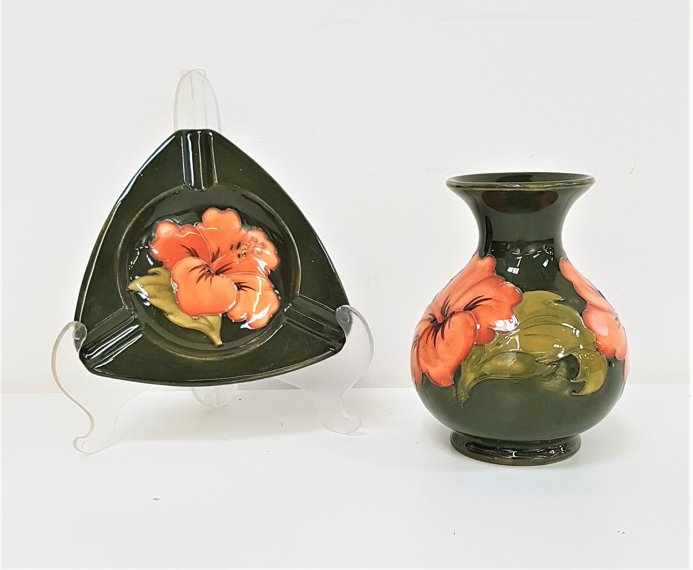 MOORCROFT BALUSTER VASE decorated in the hibiscus pattern with a green ground, 13cm high, together