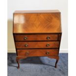 MAHOGANY QUARTER VENEERED BUREAU with a fall flap opening to reveal a fitted interior above three