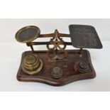 19th CENTURY SET OF POSTAL SCALES raised on a shaped base with various weights, the scales with