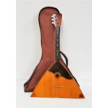 RUSSIAN BALALAIKA with a an arched back and flat triangular front, with three strings, in a soft