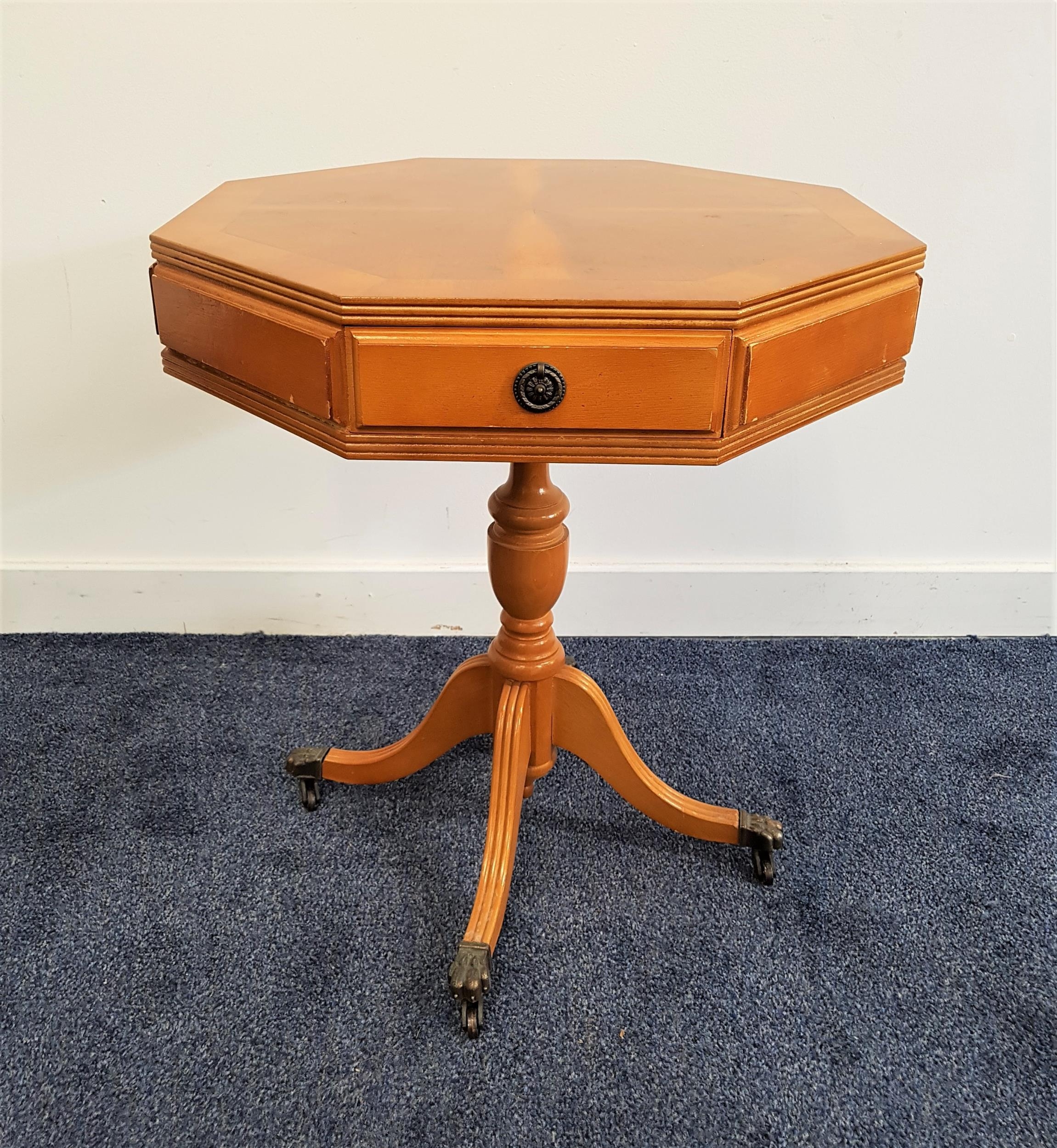 YEW AND CROSSBANDED OCTAGONAL OCCASIONAL TABLE with a segmented top above a frieze drawer and