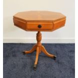 YEW AND CROSSBANDED OCTAGONAL OCCASIONAL TABLE with a segmented top above a frieze drawer and