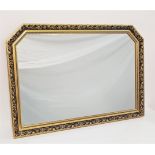 LARGE SHAPED GILTWOOD MIRROR in a decorative frame with a plain plate, 102.5cm wide