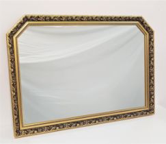LARGE SHAPED GILTWOOD MIRROR in a decorative frame with a plain plate, 102.5cm wide