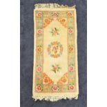 CHINESE RECTANGULAR WASH RUG with a cream ground and pale blue floral border, fringed, 158cm x