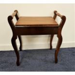 EDWARDIAN MAHOGANY PIANO STOOL with a lift up seat flanked by turned handles, standing on shaped