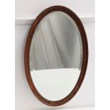 OVAL WALL MIRROR in an oak frame with a bevelled plate, 72cm high