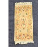 CHINESE WASH RUG with a mushroom ground and floral motifs, 156cm x 78cm