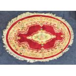 CHINESE OVAL WASH RUG with a burgundy ground and centered with flowers and encased with a floral