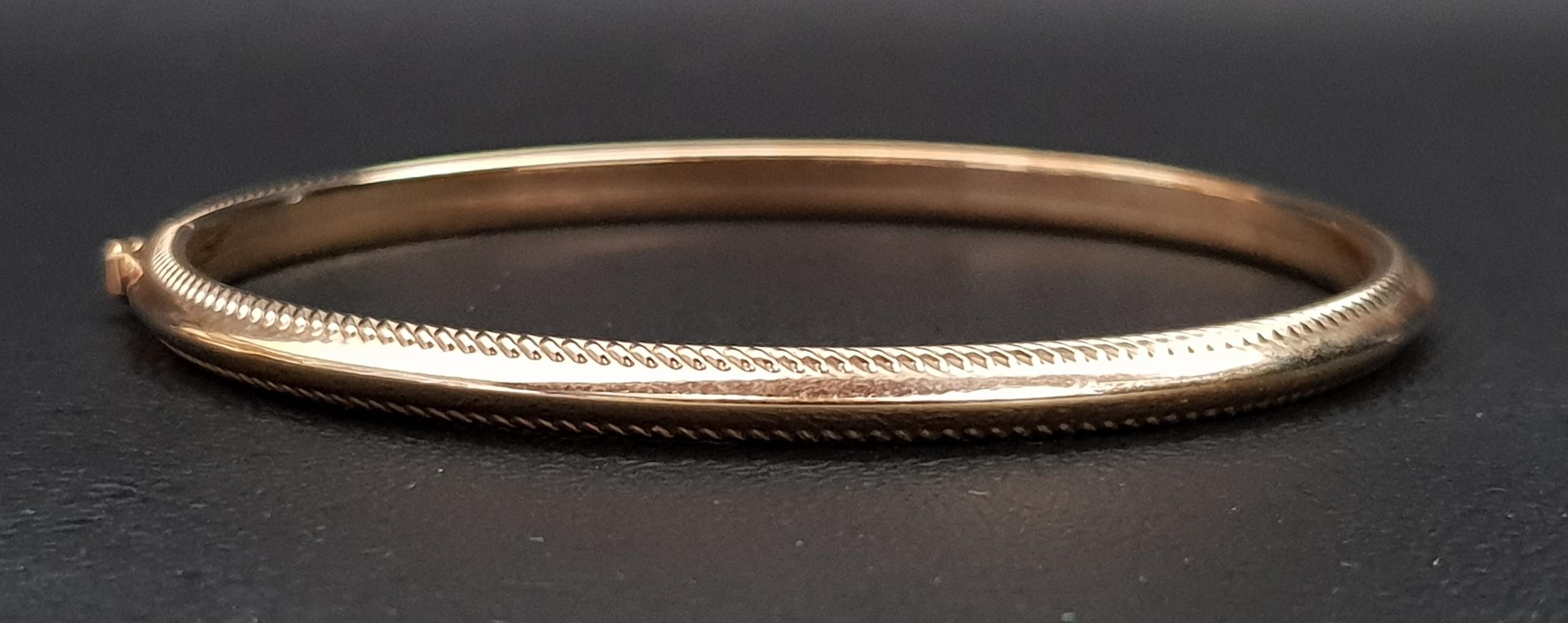 NINE CARAT GOLD BANGLE with ribbed edge detail and safety clasp, approximately 4.3 grams - Image 2 of 2