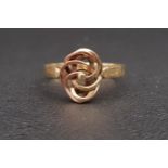 FOURTEEN CARAT GOLD RING with central pierced and entwined panel in rose and yellow gold, ring