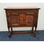 OAK SIDE CABINET with a rectangular moulded top above a carved frieze with two carved panelled doors