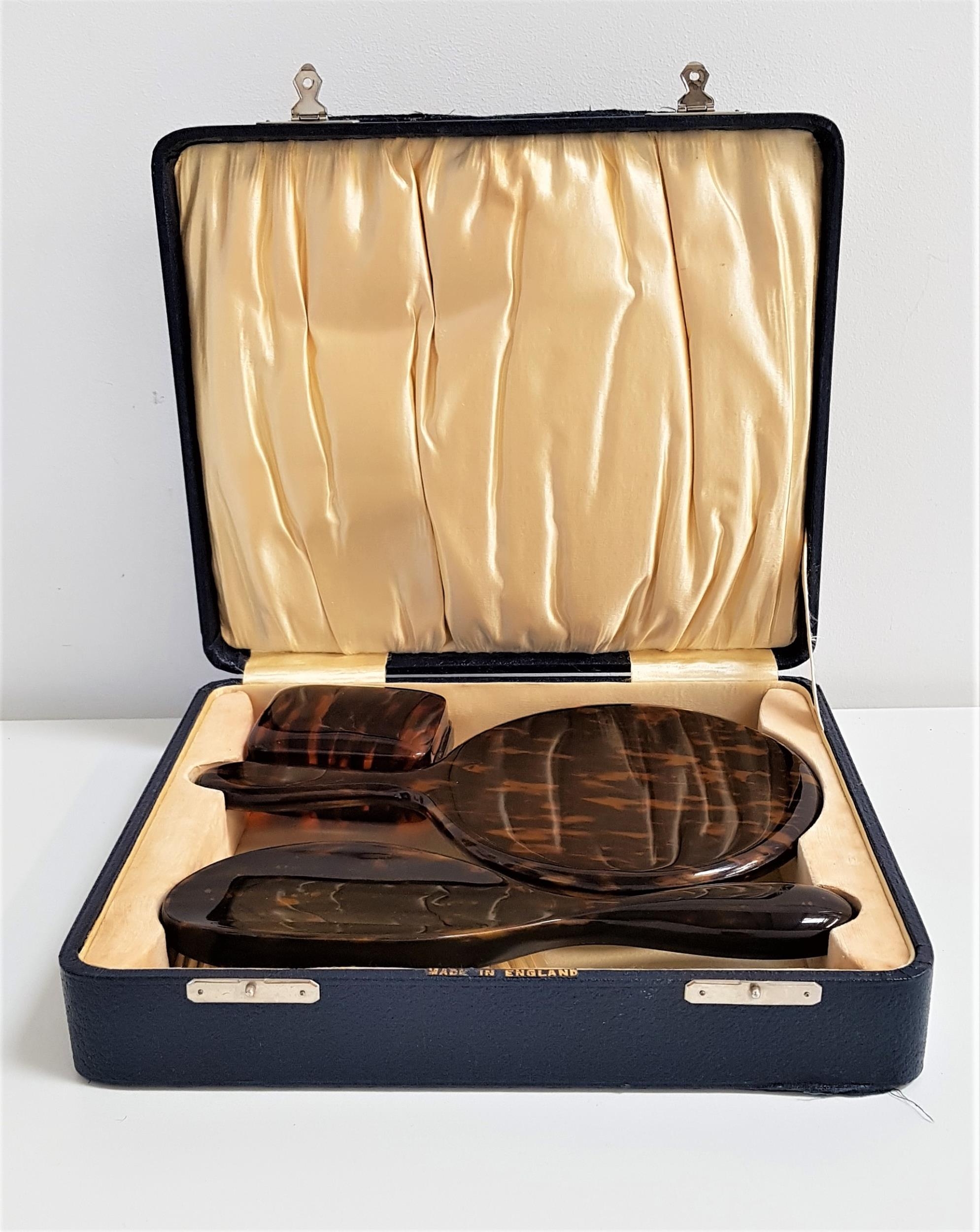 FAUX TORTOISESHELL DRESSING TABLE SET in a fitted box, comprising a hair brush, hand mirror and soap