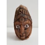 20th CENTURY CARVED COCONUT decorated with a face with painted shell eyes below the word Trinidad,