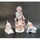 THREE LLADRO CLOWN FIGURINES comprising a larger example with dogs to either side, 25.2cm high;