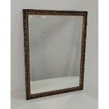 RECTANGULAR WALL MIRROR with a bevelled plate and a carved and pierced giltwood frame, 67cm x 52cm