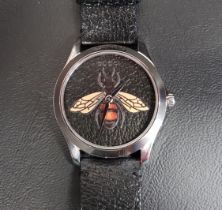 GUCCI G-TIMELESS BLACK BEE WATCH the circular black dial textured to match the strap and having a
