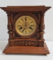 GERMAN WALNUT MANTLE CLOCK the circular dial with Roman numerals, the rear door with a paper