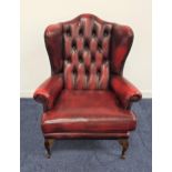 CHESTERFIELD SHAPED WINGBACK ARMCHAIR in ox blood red leather with a button back and scroll arms