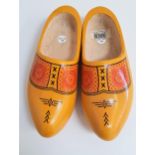 PAIR OF DUTCH CARVED CLOGS of one piece construction and painted yellow with a geometric design,