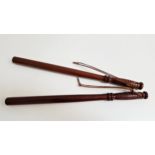 TWO MAHOGANY TRUNCHEONS with turned ribbed handles and leather wrist straps, each 55.5cm long (2)