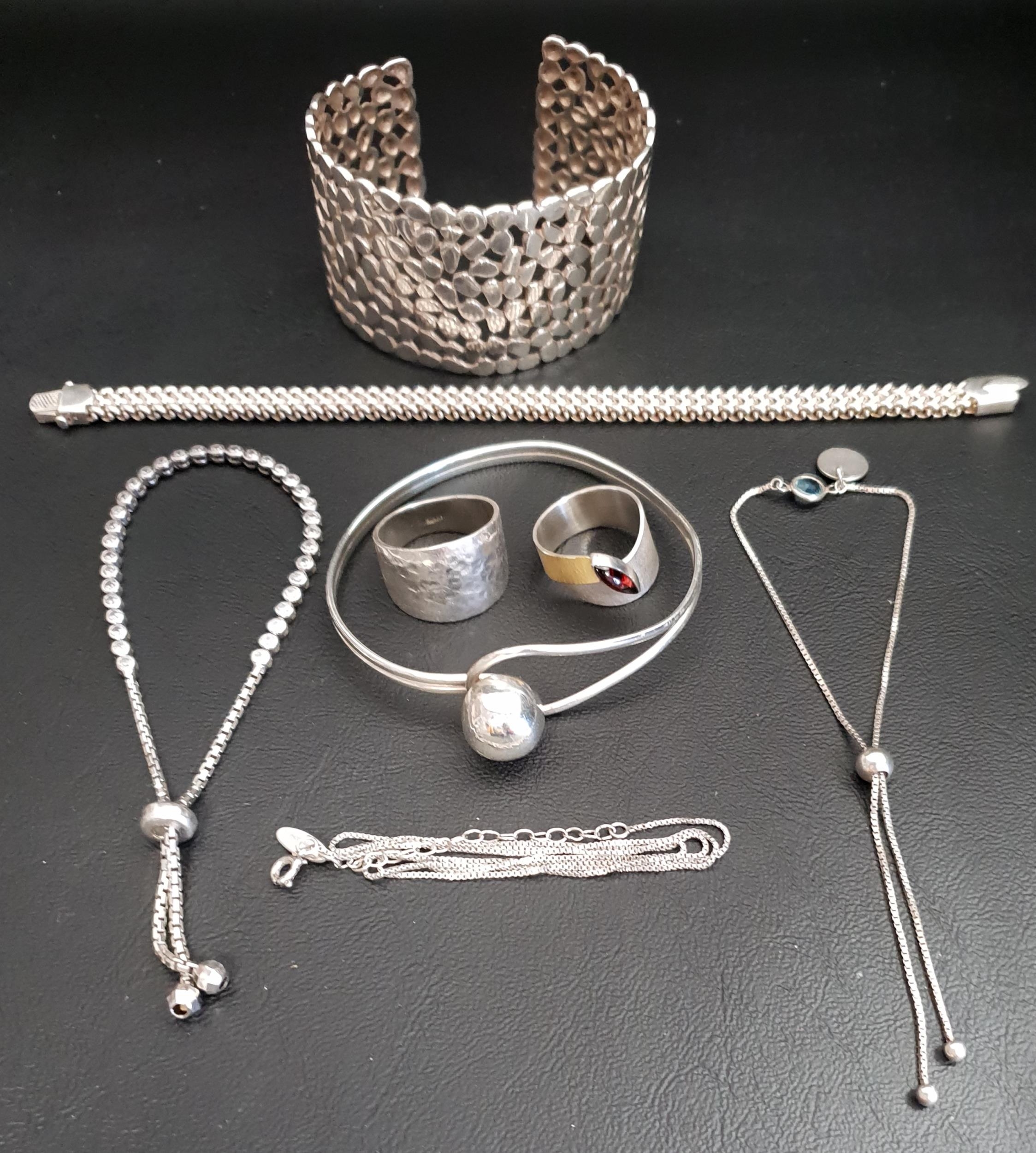 SELECTION OF SILVER JEWELLERY comprising a pierced cuff bangle, another ball clasp bangle, three