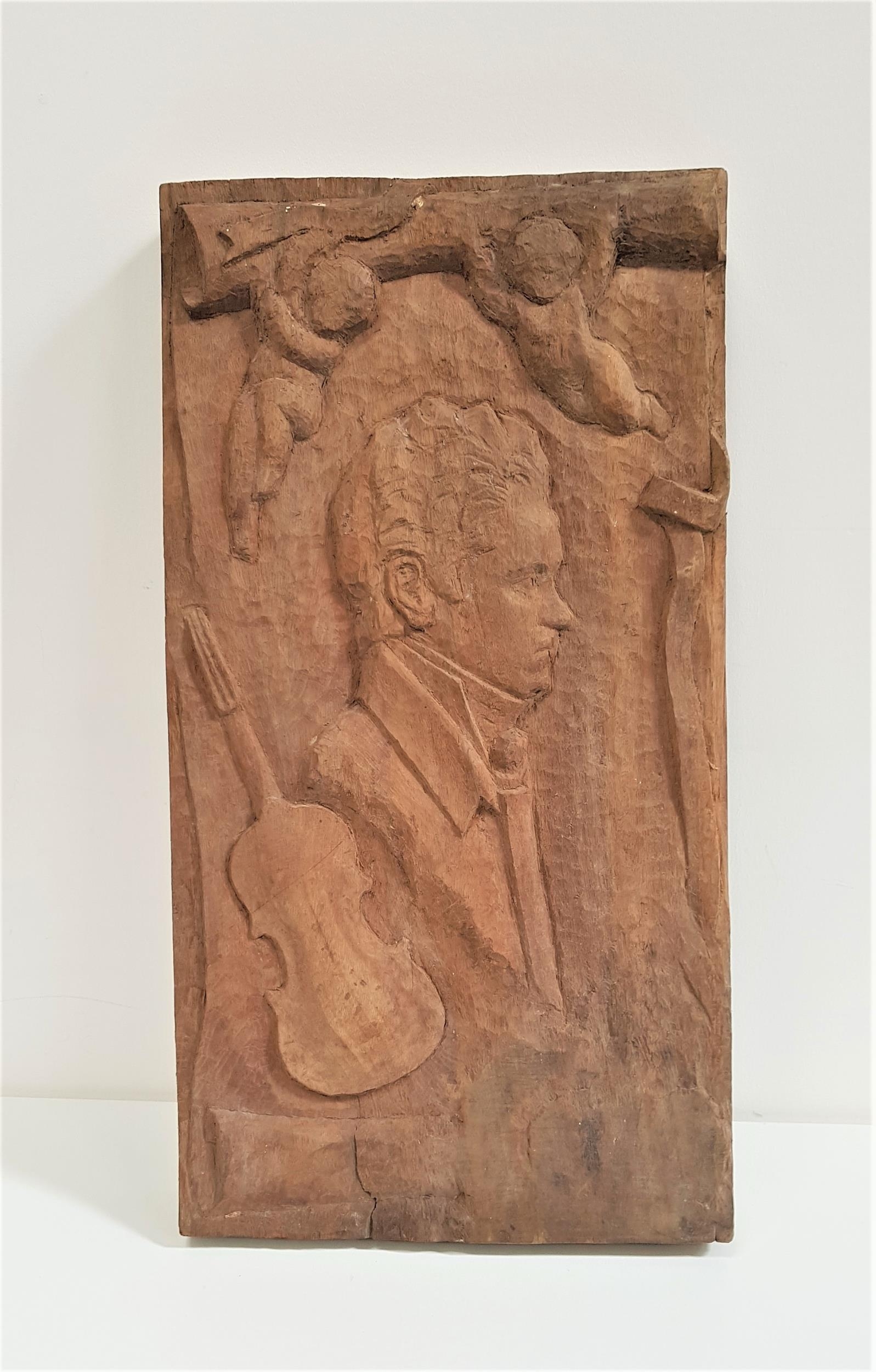 LARGE MAHOGANY CARVED PANEL depicting Robert Burns in profile, a violin and two cherubs, 72cm x 38cm