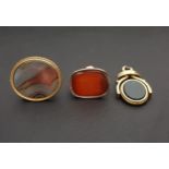 THREE VARIOUS FOBS all in gold plated mounts, comprising a carnelian seal fob with engraved