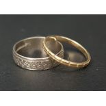 TWO NINE CARAT GOLD RINGS comprising one thin yellow gold ring with raised double bar design and a