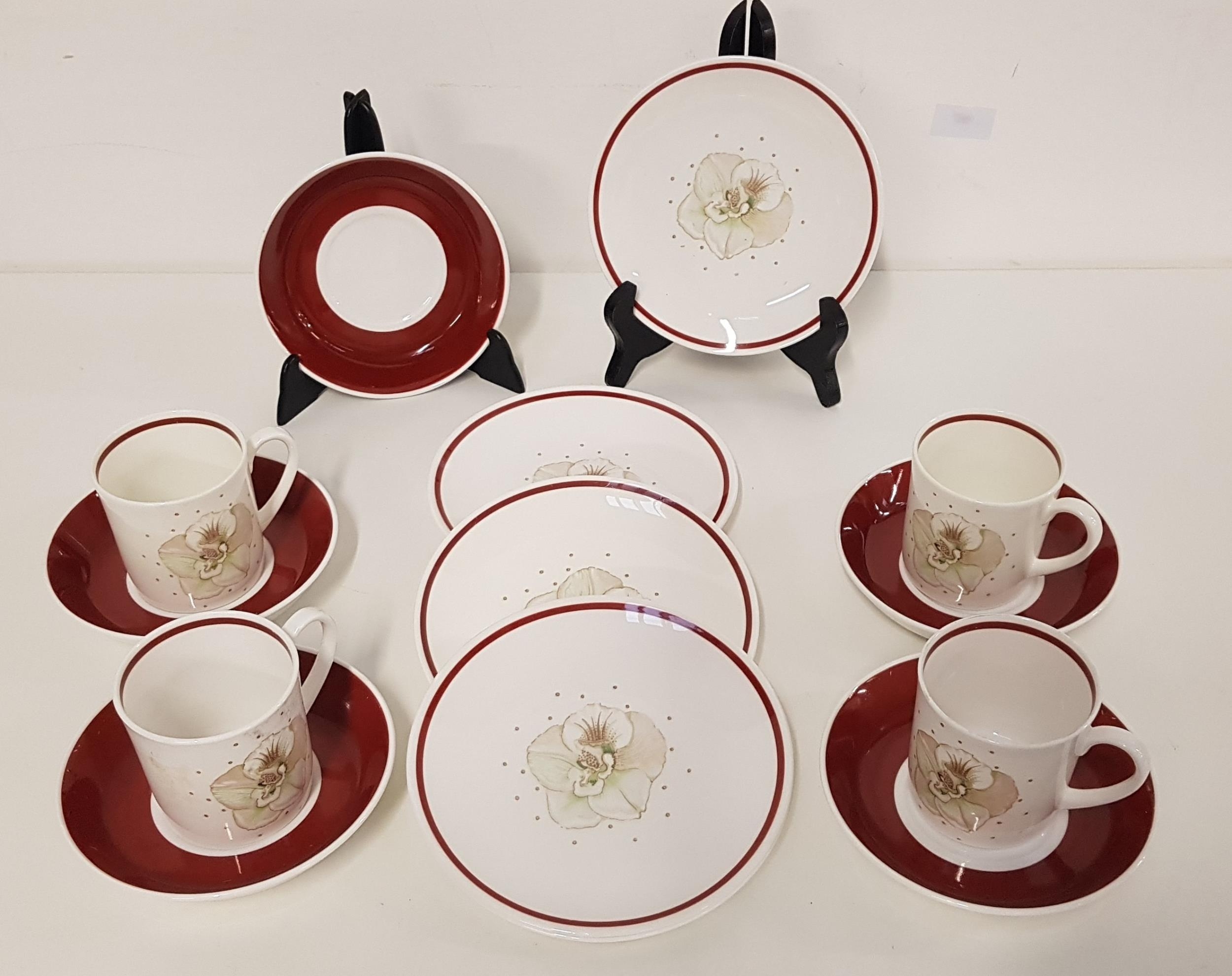 SUSIE COOPER COFFEE SET with a white and burgundy ground, the cups with floral decoration,