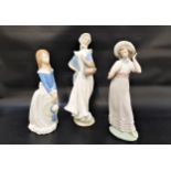THREE NAO FIGURINES comprising a girl holding her hat, 28cm high, a girl holding a basket of