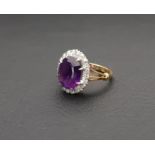 AMETHYST AND DIAMOND CLUSTER RING the large central oval cut amethyst measuring approximately 11.7mm
