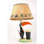 A Carltonware Guinness ceramic advertising table lamp in the form of a toucan standing on a grassy