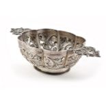 Dutch silver brandy bowl, the oval lobed body repousse decorated with scrolling foliate motifs,