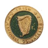 Irish National Volunteers. A die-stamped, gilt-metal buttonhole badge, a relief harp in a green