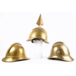 Fireman's helmets. Three brass fireman's helmets, the crowns with combs, the brims with rolled