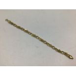 A 9ct gold bracelet with alternating curb and flower head style links, 19cm long, approx. 4.8g