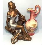 A painted ceramic sculpture of a seductive lady seated on rocks, 40cm tall, together with a