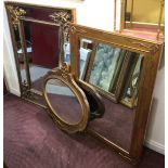 A large rectangular mirror with bevelled side panels and stylised spandrels to beaded inner frame.