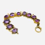 A 15ct yellow gold amethyst bracelet set with 10 x oval faceted amethysts in an articulated ball and