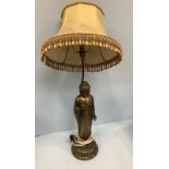 A brass figural lamp modelled as a standing Buddha, with shade, 95cm tall including shade,