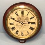 An oak cased circular quartz wall clock by John Carter, with coat of arms to dial and Roman numerals