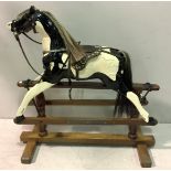 An early 20th century rocking horse, repainted in black and white, mane and tail intact, raised on