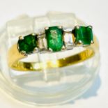 An 18ct yellow gold emerald and diamond ring, set with 3 x emeralds and 2 x emerald cut diamonds,