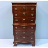 A Reproduction mahogany small chest-on-chest of serpentine form, with brass handles and escutcheons,