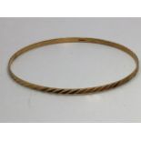 An 18ct gold stiff bangle marked '750', approx. 4.6g