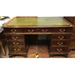 A reproduction mahogany pedestal desk, the top with gilt-tooled green leather scribe and with