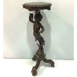 A Victorian stained wood and carved figural torchere stand, with shaped top and supported by a