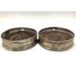 A pair of George III silver wine bottle coasters, with pierced sides and bright-cut decoration,
