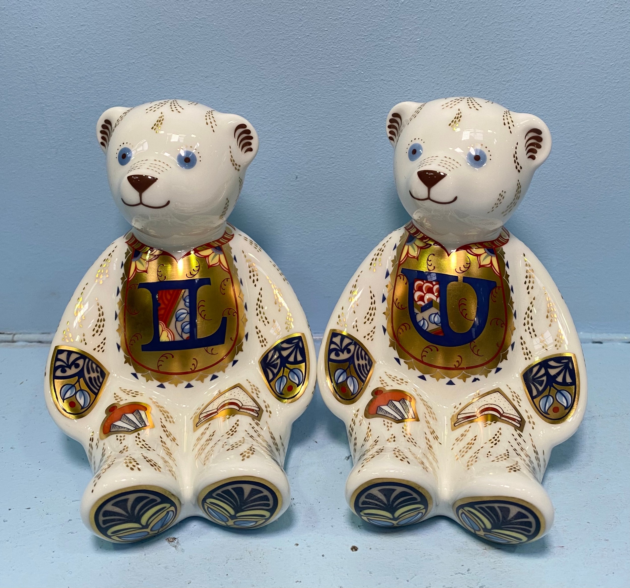 A pair of Royal Crown Derby Alphabet Bears, 'U' and 'L', with printed marks to base, gold stoppers